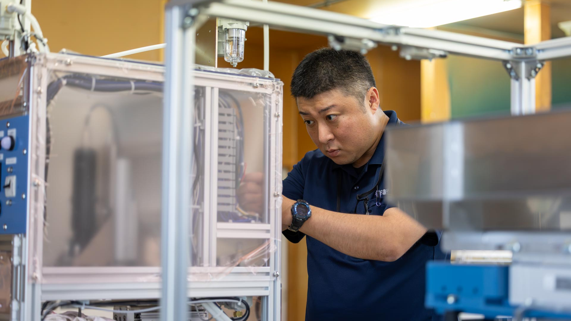 工場内で設計図面を確認しながら作業を行う技術者